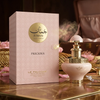 Prabangus "Juman Precious" produkto pristatymas parfumuotas vanduo, su švelnaus tono 100 ml buteliuku, eksponuojamu šalia puošnios, raštuotos dovanų dėžutės ant elegantiško marmuro paviršiaus.